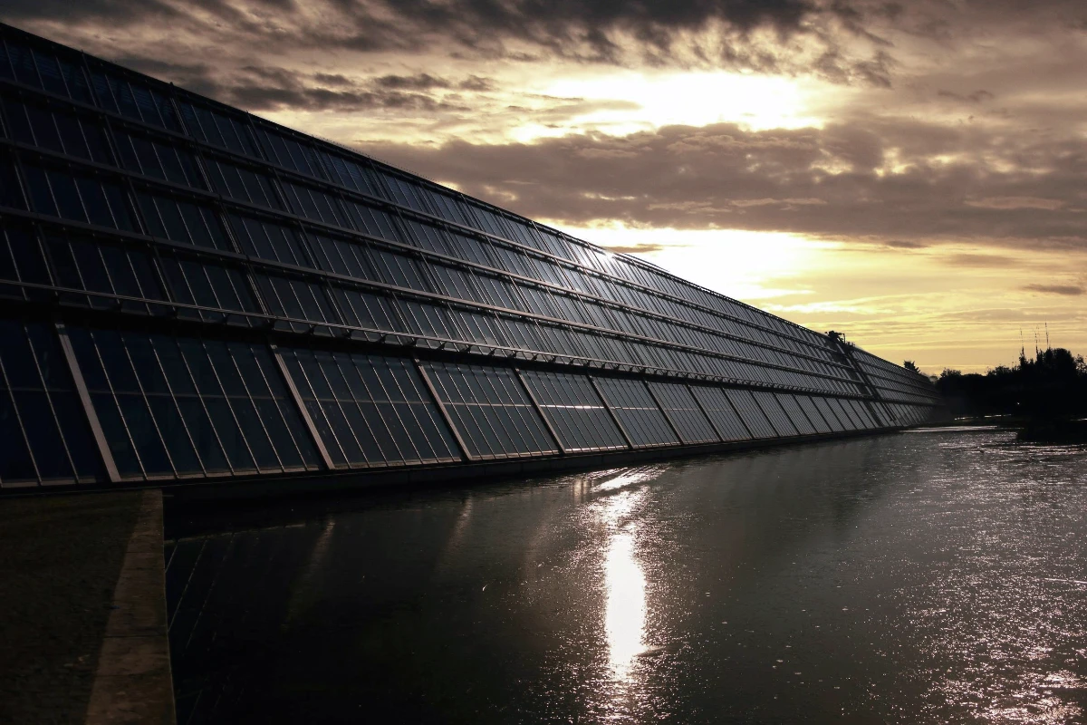 solar panels on the side of a building next to a waterway